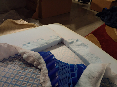 Picture of a corner of buckling gel being extracted from a mattress topper